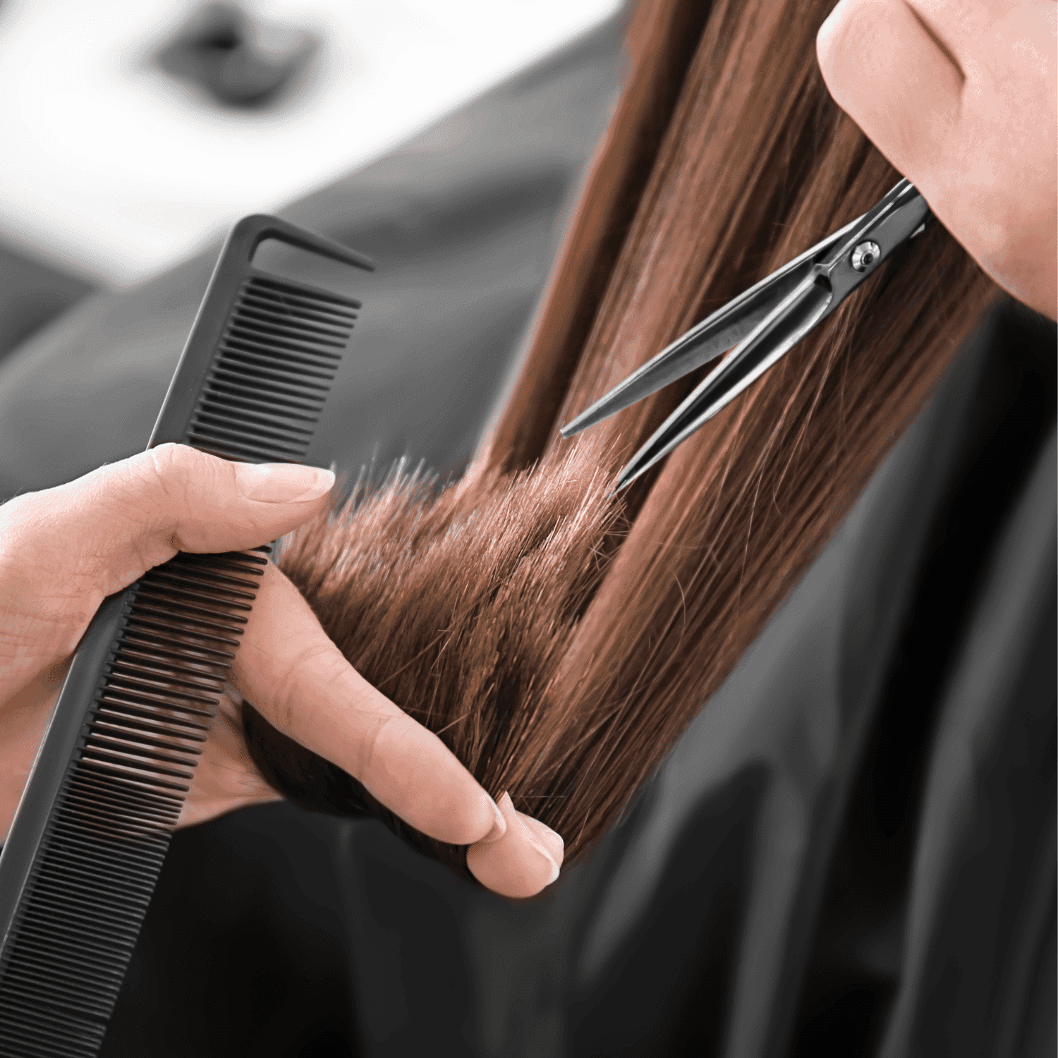Hairstylist using scissors and comb to trim long brown hair.